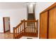 Carpeted stairs with wooden railing and trim lead to the upper level of this home at 3948 S Woodfield Dr, New Palestine, IN 46163