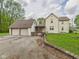 Home with a two-car garage and a welcoming stone entrance, featuring manicured landscaping at 4079 S 50 W, Anderson, IN 46013