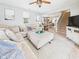Bright living room featuring a large sectional couch, staircase, and view of dining area at 4079 S 50 W, Anderson, IN 46013