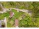 Aerial view capturing the home nestled amongst verdant trees, showcasing surrounding properties and the gravel driveways at 4091 W Briarwood Lake S Dr, Monrovia, IN 46157