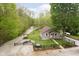 Aerial image of a home with a yard featuring a pond, firepit, mature trees, and an outbuilding surrounded by green space at 4091 W Briarwood Lake S Dr, Monrovia, IN 46157