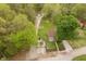 This aerial view captures multiple homes, nestled within lush greenery, driveways, and outbuildings adding to the serene landscape at 4091 W Briarwood Lake S Dr, Monrovia, IN 46157