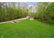 Expansive backyard with a lush lawn, shed, and natural wooded border at 4091 W Briarwood Lake S Dr, Monrovia, IN 46157