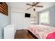 Inviting bedroom featuring a ceiling fan, closet, TV, a built-in bookshelf, and a large window at 4091 W Briarwood Lake S Dr, Monrovia, IN 46157