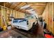 Inside of a wood-walled garage featuring a painted pickup truck, fluorescent lighting, tools, air conditioning unit, and a vacuum at 4091 W Briarwood Lake S Dr, Monrovia, IN 46157