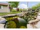 Scenic pond with a waterfall feature, landscaping, and aquatic life at 4091 W Briarwood Lake S Dr, Monrovia, IN 46157