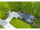 Aerial perspective of a brick home with a well-kept lawn, gravel driveway, and a backdrop of lush trees and foliage at 4291 E Lakeview Dr, Martinsville, IN 46151