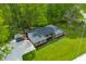 Aerial view of a brick home featuring a well-manicured lawn, gravel driveway, and mature trees in a serene setting at 4291 E Lakeview Dr, Martinsville, IN 46151