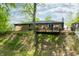 Brick house backyard featuring a wooden deck, fenced yard, and mature trees, perfect for outdoor living and privacy at 4291 E Lakeview Dr, Martinsville, IN 46151