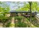 Brick house backyard boasting a wooden deck and fenced yard, surrounded by lush greenery and mature trees at 4291 E Lakeview Dr, Martinsville, IN 46151