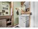 Rustic bathroom featuring wood accents, round mirror, and laundry themed decor at 4291 E Lakeview Dr, Martinsville, IN 46151