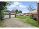 Expansive backyard featuring a two-car detached garage, partial fencing, and a gravel parking area at 4730 Rookwood Ave, Indianapolis, IN 46208