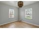 Cozy bedroom with two windows, hardwood flooring and modern lighting fixture at 4730 Rookwood Ave, Indianapolis, IN 46208