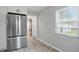 A kitchen area with a stainless refrigerator, a window and grey tile floors at 4730 Rookwood Ave, Indianapolis, IN 46208