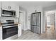 Spacious kitchen featuring stainless steel appliances, gray floors, and white cabinets at 4730 Rookwood Ave, Indianapolis, IN 46208