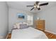 Comfortable bedroom with hardwood floors, a ceiling fan, and a large window with natural light at 5526 Indianola Ave, Indianapolis, IN 46220