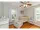 Bedroom featuring hardwood floors, a crib, and a comfortable armchair for relaxing with a baby at 5526 Indianola Ave, Indianapolis, IN 46220