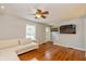Cozy living room featuring hardwood floors, a neutral sofa, and a wall-mounted television at 5526 Indianola Ave, Indianapolis, IN 46220