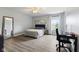Bedroom with wood-look floors, a ceiling fan, neutral walls, a desk, and a large mirror on the wall at 5851 Grand Ave, Plainfield, IN 46168