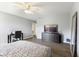 Bedroom with wood-look floors, mounted television, neutral walls, and a black desk with a rolling chair at 5851 Grand Ave, Plainfield, IN 46168