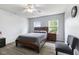 Bedroom with wood-look floors, ceiling fan, and natural light from two windows, plus side tables and chairs at 5851 Grand Ave, Plainfield, IN 46168