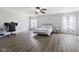 Bright bedroom features wood floors, neutral walls, ceiling fan, and ample natural light from two large windows at 5851 Grand Ave, Plainfield, IN 46168