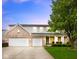 Charming two-story brick home featuring a spacious three-car garage and manicured lawn at 5851 Grand Ave, Plainfield, IN 46168