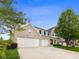 Two-story home with a three-car garage, showcasing a well-maintained lawn and mature tree at 5851 Grand Ave, Plainfield, IN 46168