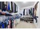 Walk-in closet with carpet flooring, a built-in shoe rack, and multiple racks for folded and hanging clothes at 5851 Grand Ave, Plainfield, IN 46168