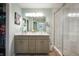 Bathroom boasting double vanity, framed mirror, and glass shower with white tile and neutral walls at 610 Redwood Dr, Pendleton, IN 46064