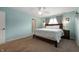 Cozy bedroom with light blue walls, ceiling fan, plush carpet, and a neatly made bed at 610 Redwood Dr, Pendleton, IN 46064