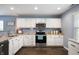 Bright kitchen with white cabinets, granite countertops, stainless steel appliances, and wood-look flooring at 610 Redwood Dr, Pendleton, IN 46064