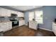 Well-lit kitchen showcasing white cabinets, stainless steel appliances, granite countertops, and wood-look floors at 610 Redwood Dr, Pendleton, IN 46064