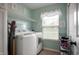 Well-lit laundry room with washer, dryer, wire shelving, and a window for natural light at 610 Redwood Dr, Pendleton, IN 46064