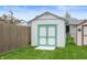 Exterior shot of a backyard storage shed with double doors and ample green space at 610 Redwood Dr, Pendleton, IN 46064