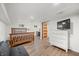 Finished basement bedroom with wood flooring, a large bed, and a mounted television at 6250 Seminole Dr, Indianapolis, IN 46259