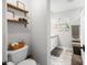 Stylish bathroom featuring floating shelves, patterned floor, and modern fixtures at 6250 Seminole Dr, Indianapolis, IN 46259