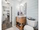 Bathroom with wooden vanity, toilet, and a view of the kitchen in the background at 6250 Seminole Dr, Indianapolis, IN 46259