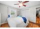 Charming bedroom with hardwood floors, a ceiling fan, a comfortable bed, and bright natural light at 6250 Seminole Dr, Indianapolis, IN 46259