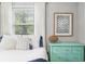 Well-lit bedroom featuring hardwood floors, bright natural light, and stylish decor with a turquoise dresser at 6250 Seminole Dr, Indianapolis, IN 46259