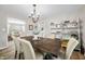 Bright dining room with a wooden table, chandelier, and open shelving with decorative items at 6250 Seminole Dr, Indianapolis, IN 46259