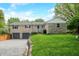 Beautiful stone home with attached two-car garage, well-kept lawn, and mature trees with a swing at 6250 Seminole Dr, Indianapolis, IN 46259