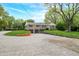 Charming stone home featuring an attached two-car garage, manicured lawn, and beautiful mature trees at 6250 Seminole Dr, Indianapolis, IN 46259