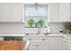 Bright kitchen with stainless steel sink, subway tile backsplash, and a view of trees outside the window at 6250 Seminole Dr, Indianapolis, IN 46259