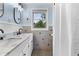 Bright bathroom featuring double sinks, a marble countertop, black fixtures, and a window bringing in natural light at 6288 Buttonwood Dr, Noblesville, IN 46062