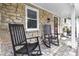 Inviting front porch with stone accents and a pair of rocking chairs creating a cozy outdoor space at 6288 Buttonwood Dr, Noblesville, IN 46062