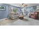 Cozy living room with blue walls, a ceiling fan, a comfortable couch and a large window at 6288 Buttonwood Dr, Noblesville, IN 46062