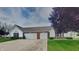 Charming exterior elevation of a two-car garage home with brick accents and well-manicured landscaping at 7018 Mallard Way, Plainfield, IN 46168