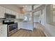 Modern kitchen with stainless steel appliances, white cabinets, and an open view to the living area at 7018 Mallard Way, Plainfield, IN 46168