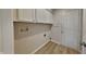 Functional laundry room with overhead cabinets and easy access to an exterior door at 7018 Mallard Way, Plainfield, IN 46168